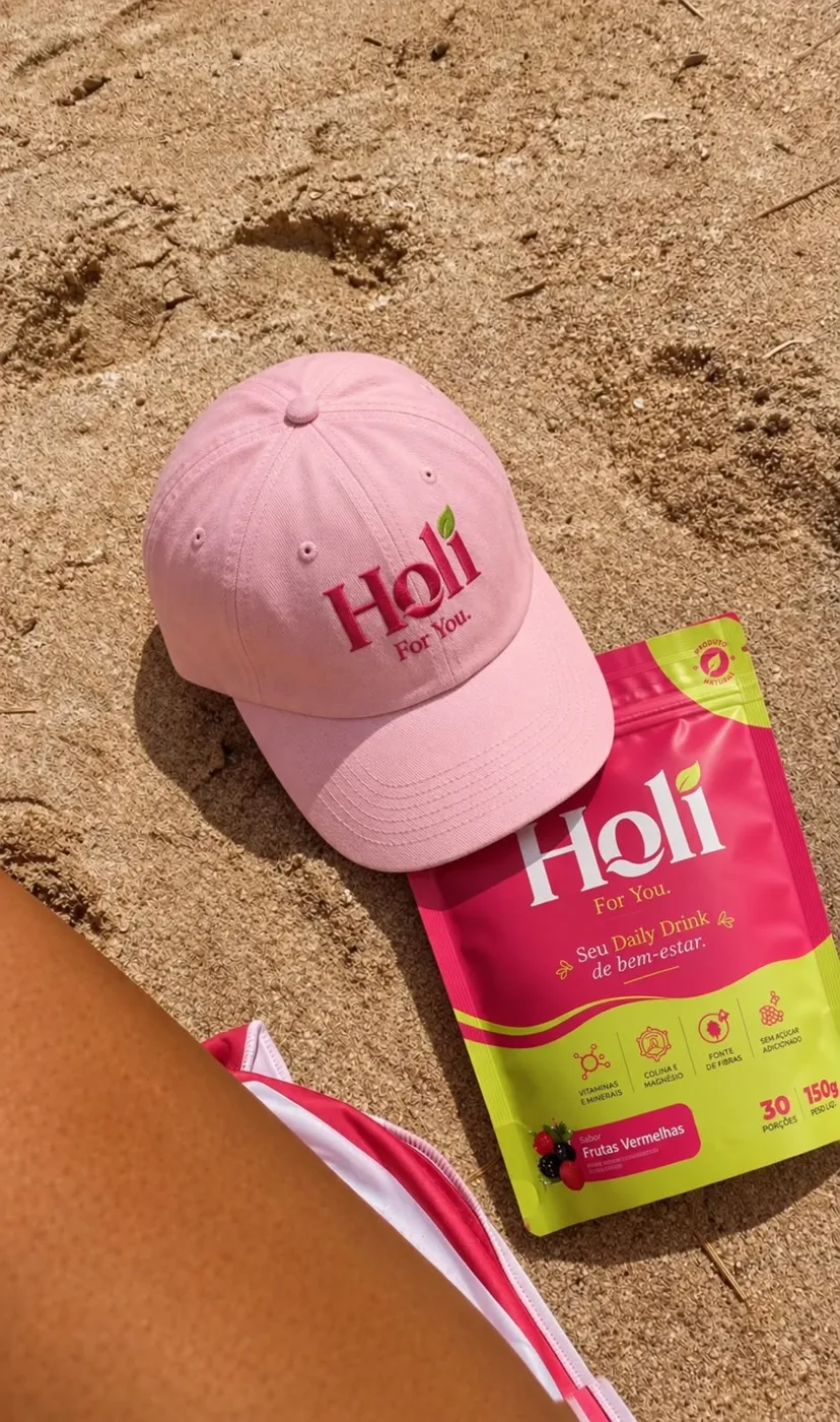 Boné rosa Holi e pouch na areia da praia